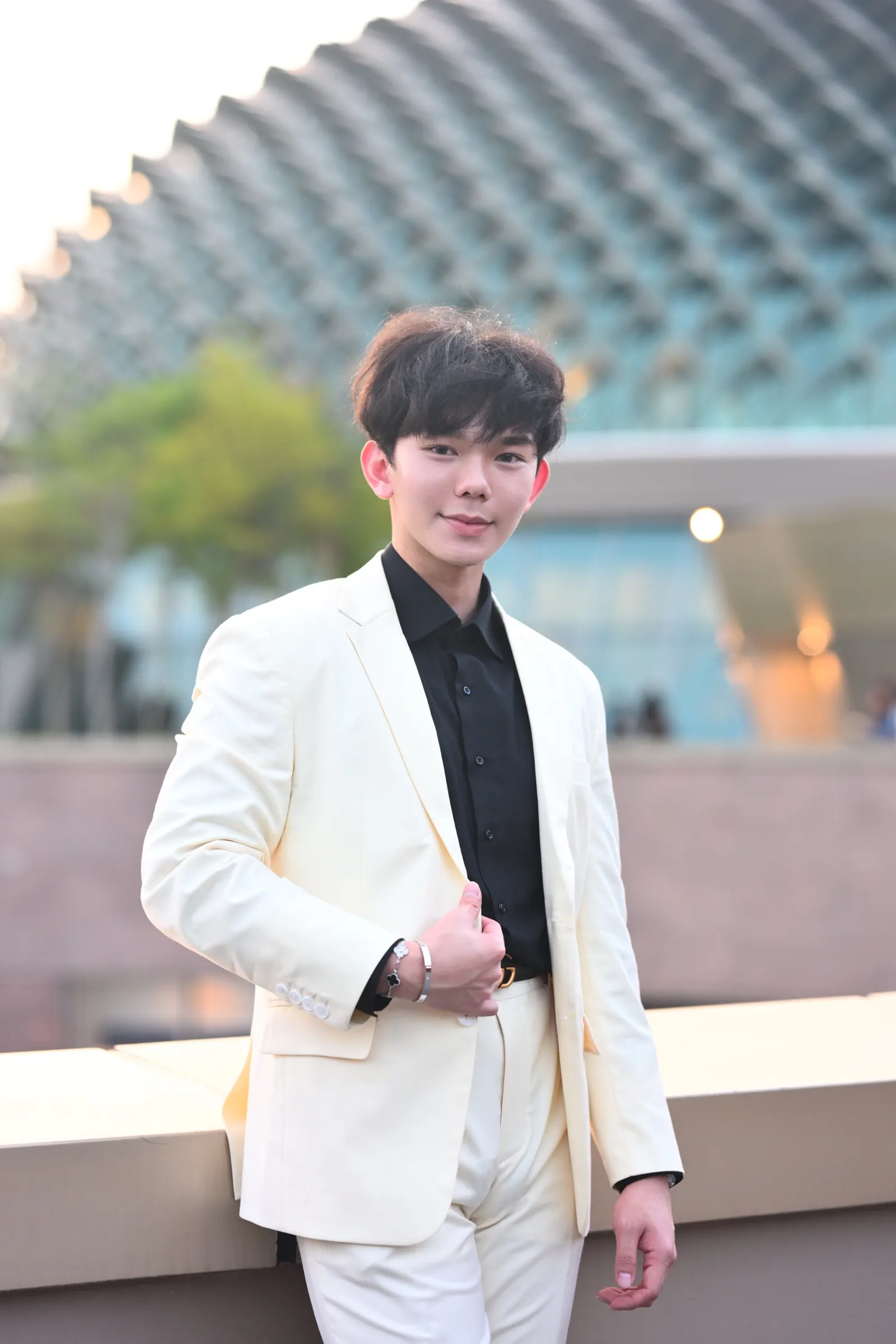 Terence Poo in a cream suit and black shirt outside the Esplanade, Singapore